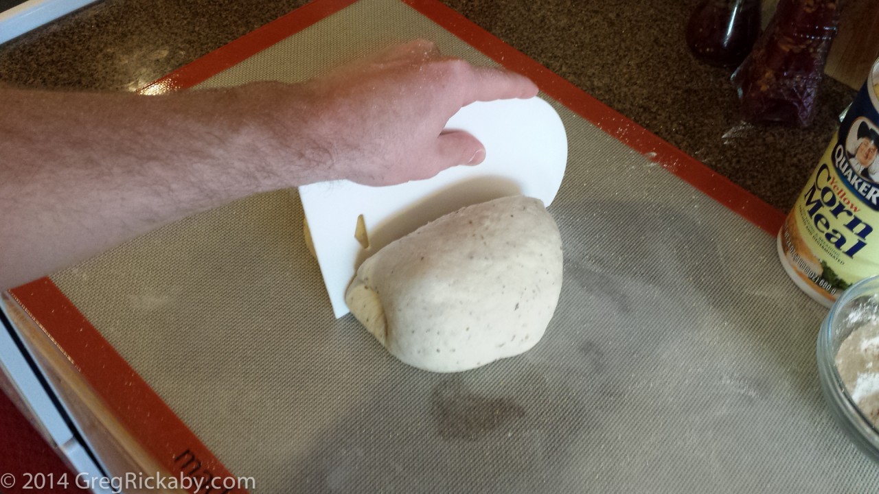 Cover the dough with a little flour and cornmeal and form into a ball. Cut in half.